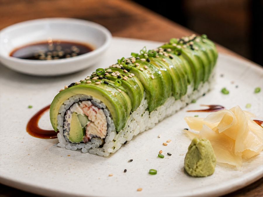 Roll de sushi cubierto con láminas de palta